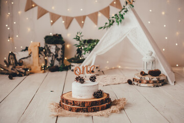 stylish light photo zone with a cake, one topper and a children's hut