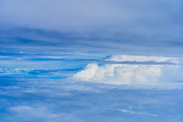 Obraz premium Landscape of fluffy white clouds on a dark blue sky. View from the plane at high altitude
