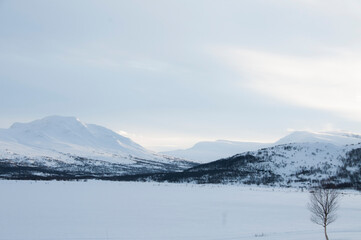 Fototapeta na wymiar mountains in the winter, behind frozen lake