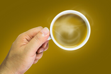 Hand holding a hot brewed coffee mug with a brown background