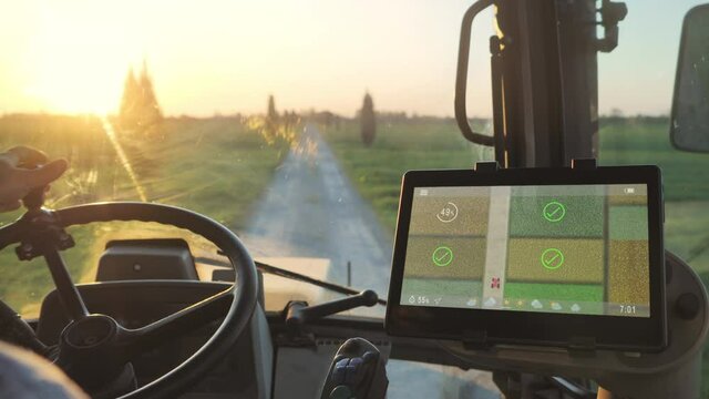 smart agriculture technology farmer using tablet application in the tractor cab to optimize the harvest,man driving tractor using touch screen display to check fields production condition