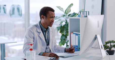 African American Young Professional Doctor Talking to Patient using Computer for Remote...