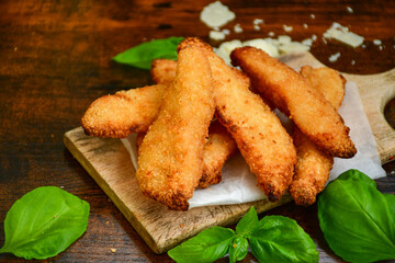 
 Crispy  deep fried home made    chicken strips Breaded  with  almond flour chicken  breast fillets  with chilly peppers and fresh   basil on wooden rustic background. Ketogenic diet food