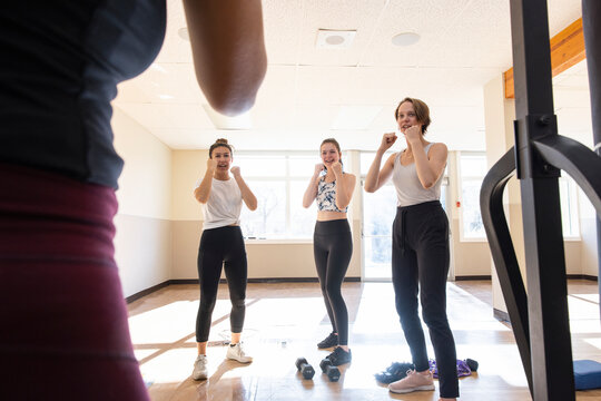Teen girls learning boxing fighting stance in gym studio