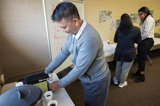Man making coffee at urban planning meeting in community center