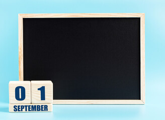 September 1. Day 1 of month, Cube calendar with date, empty frame on light blue background. Place for your text. Autumn month, day of the year concept