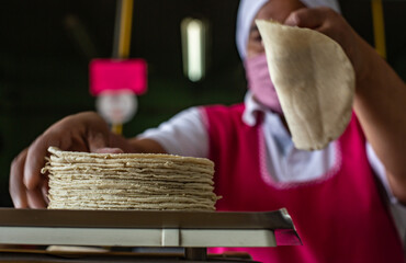 una mujer pesa un kilo de tortilla en la báscula 