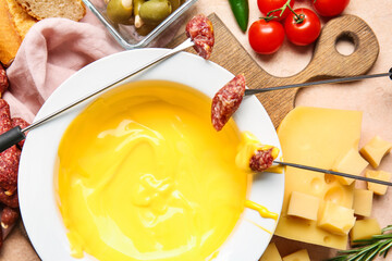 Sticks with sausage dipped into cheese fondue, closeup