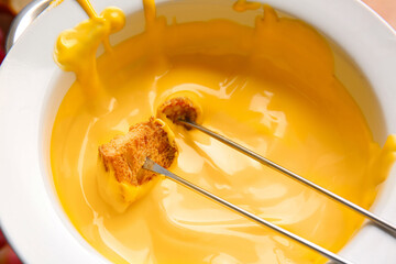 Stick with crouton dipped into cheese fondue, closeup