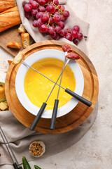 Cheese fondue and different snacks on light background