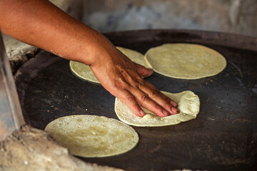 Una mujer prepara una tortilla en el comal