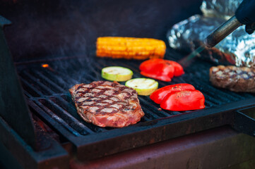 Beef steaks on the grill with flames