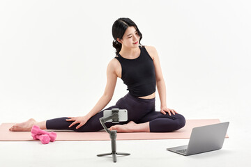 Obraz premium Asia Korean Girl training at white background , watching videos on laptop, and live streaming using gimbal in sns
