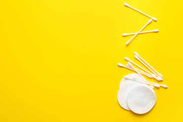 Cotton pads and swabs on color background