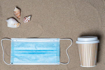 coffee cup, seashells and medical mask, top view, there is a place for text. Summer vacation concept by the sea