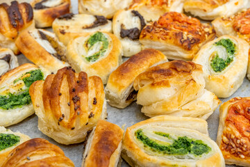 Homemade baking concept, mini pizza rolls, puff pastry rolls snacks with cheese and with black and green olives