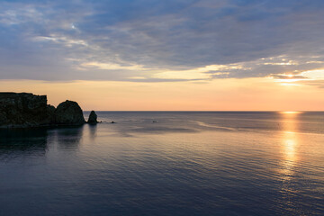 Fototapeta premium Sunset on the sea in front of a cape in the Aegean Sea on the island of Lemnos