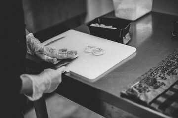 mains de Femme qui prépare des crevettes dans un restaurant avec un couteau et des gants