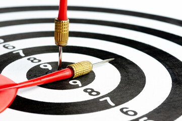 Red arrow hit on target dart board, business strategy planning to success goal.