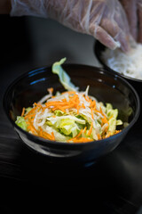 Préparation d'une salade dans un restaurant asiatique avec de la salade et des phat thai