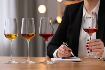 Sommelier tasting different sorts of wine at table indoors, closeup