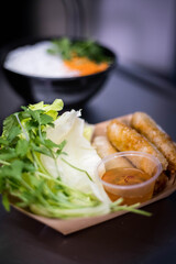 Présentation de Nems dans une barquette en carton dans un restaurant asiatique