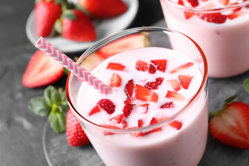 Delicious drink with strawberries in glass on table, closeup