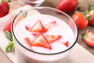 Delicious drink with strawberries in glass on table, closeup
