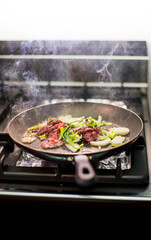 Cuisson de bœuf et de légumes dans une poêle dans un restaurant asiatique