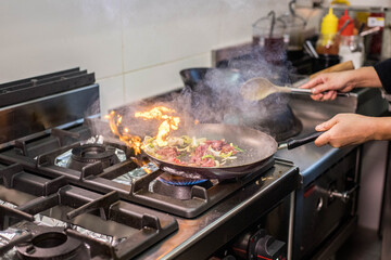 Cuisson de bœuf et de légumes dans une poêle dans un restaurant asiatique