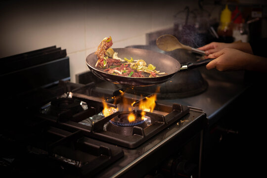 Cuisson de b&oelig;uf et de l&eacute;gumes dans une po&ecirc;le dans un restaurant asiatique