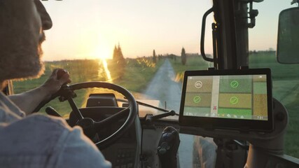 farmer male driving tractor uses smart display touch screen application to check the fields of the farm,agriculture new technology app onboard of agricultural machine,modern farmhouse startup