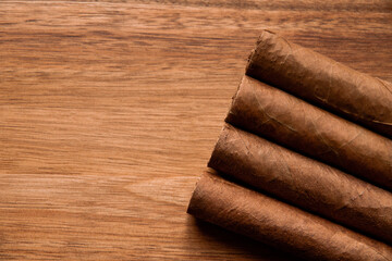 Group of brown cuban cigars on wooden background