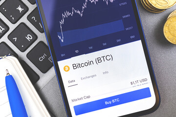 Using smartphone for buying BTC bitcoin cryptocurrency, buy button and growth chart on the srceen