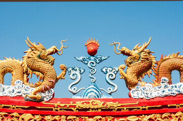 Gold dragon statue on red roof, religion symbol tradition culture.