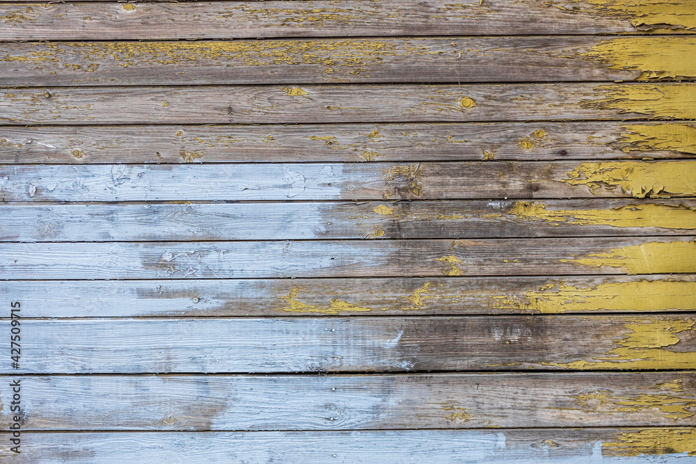 Wall mural wooden wall with horizontal planks with old blue and yellow paint