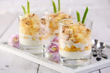 Chicken salad with pineapple, corn, seasoned with Greek yogurt, crushed nuts and grated cheese. A salad in a glass, a great idea for serving food in portions.