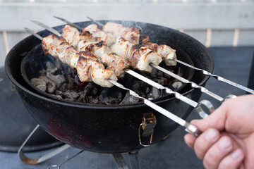 B-B-Q. Cooking barbecue on the grill. A man turns over skewers with meat Traditional picnic on weekends, holidays and spring, summer days, Camping.