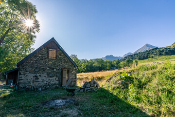 Obraz premium Authentic renovated Pyrenean barn in the Aure valley. exposed stone and wood construction. amazing view on the mountains