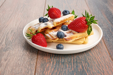 Belgian waffles with strawberries and blueberries.