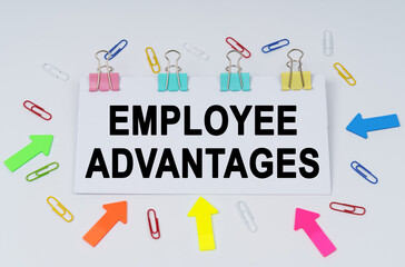 On the table there are paper clips and directional arrows, a sign that says - EMPLOYEE ADVANTAGES