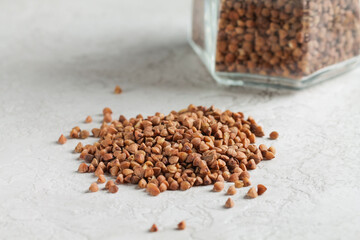 Raw buckwheat grains are scattered on the table. Healthy eating.