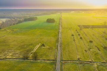 Asfaltowa droga przebiegająca przez rozległą równinę. Widok z drona.