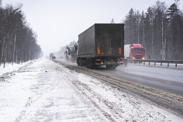 Trucks on the highway in dirty weather, Dangerous driving conditions in winter in cloudy weather.