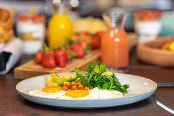 Breakfast served with eggs orange juice, croissants, strawberries Balanced diet