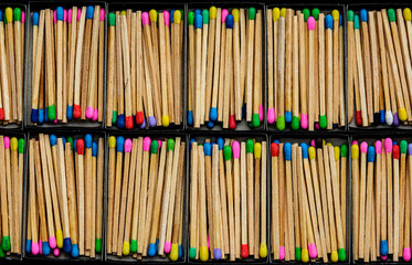 multicolored match sticks in boxes on a black background