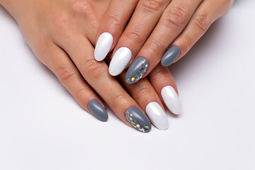 Gray, white manicure on long oval nails with glitters on nameless nails. Mirror white manicure. Rubbing on nails. Gel nail design.