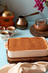 Tiramisu and coffee on a blue background.
