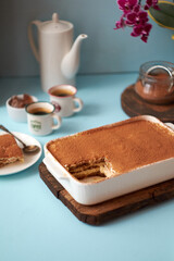 Tiramisu and coffee on a blue background.