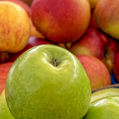 a green apple on red apple's background, fresh vegetarian food